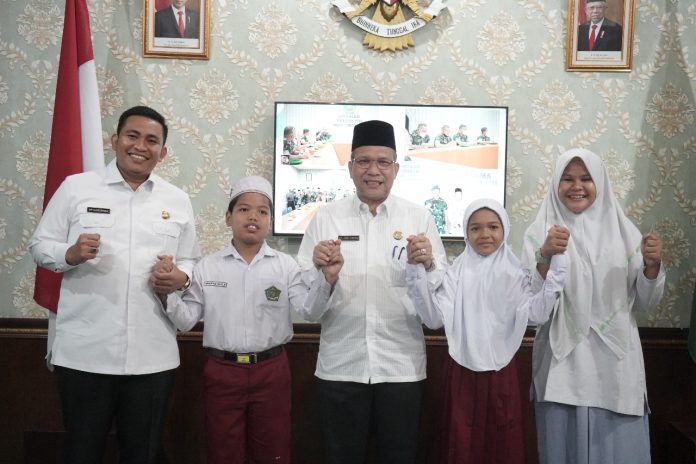 Foto: Kakanwil Kemenagsu Abd. Amri Siregar didampingi Kabid Penmad Erwin Pinayungan Dasopang foto bersama usai menerima audiensi siswa tersebut di Ruang Kakanwil Kemenagsu (dok.istimewa)