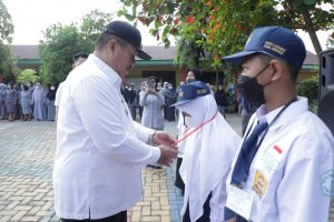 Keterangan foto : Wakil Bupati Asahan menyematkan kartu tanda dimulainya MPLS di lingkungan SMPN - 1 Kisaran ( dok/istimewa )