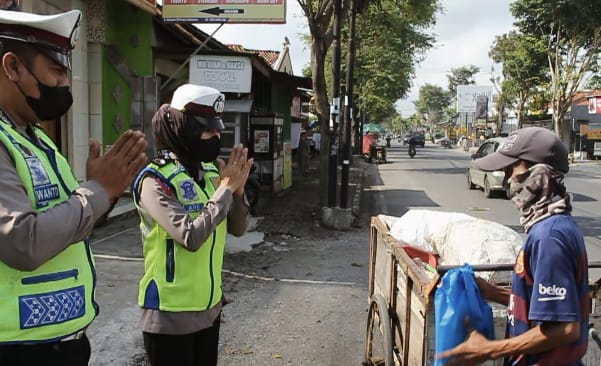 Anggota Sat Lantas Kebumen saat membagikan paket sembako kepada tukang rongsok ( Foto/Suhirman)