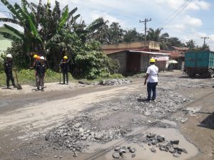 Keterangan foto : Salah seorang karyawan PTPN - 3 PKS Sei Silau didampingi Fahrul Roji dari SPBUN saat melaksanakan perbaikan infrastruktur badan jalan yang rusak ( dok/istimewa )