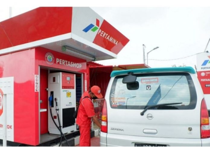 Karyawan SPBU sedang melayani konsumen