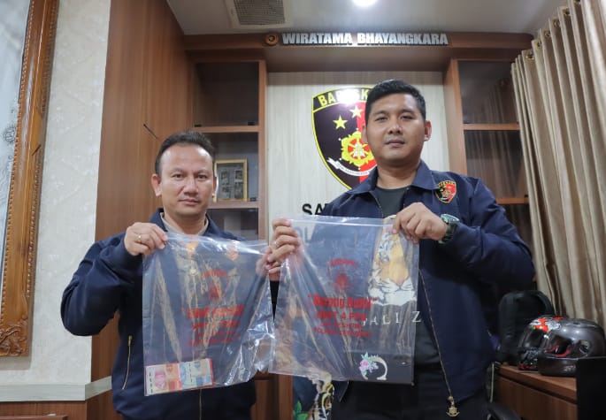 Anggota Satreskrim polres Kebumen saat menunjukan barang bukti tersangka prostitusi online (dok/Suhirman)